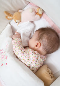 High angle view of baby girl sleeping in crib at home