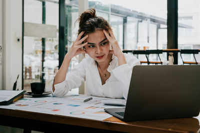 Businesswoman using laptop at office