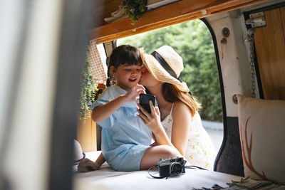 Woman using mobile phone while sitting in bus