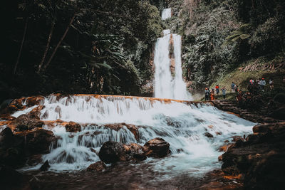 People at waterfall in forest