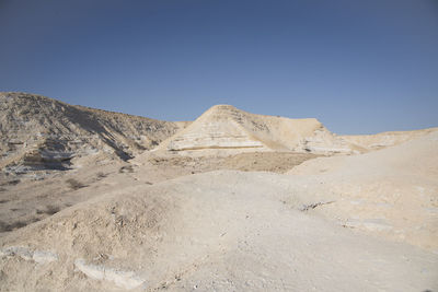 Scenic view of desert against clear blue sky