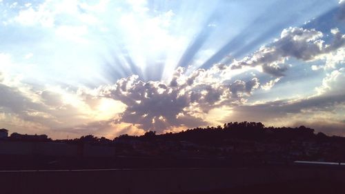 Silhouette of landscape against cloudy sky