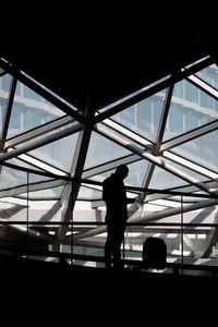 Rear view of silhouette people standing at airport