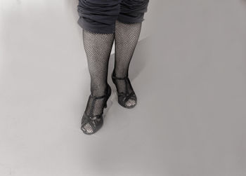 Low section of woman standing against white background