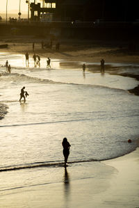 People walking on the sand of rio vermelho beach in the late afternoon.