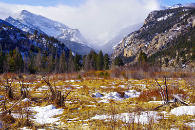 Snow covered land and mountains against sky