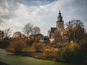 Trees and buildings against sky during autumn