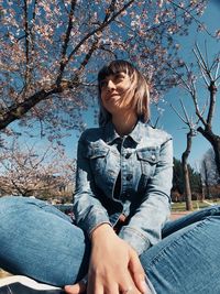 Low angle view of smiling young woman looking away in park during spring