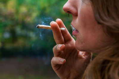Close-up of woman smoking weed outdoors