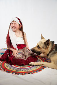 Portrait of young woman with dog sitting at home