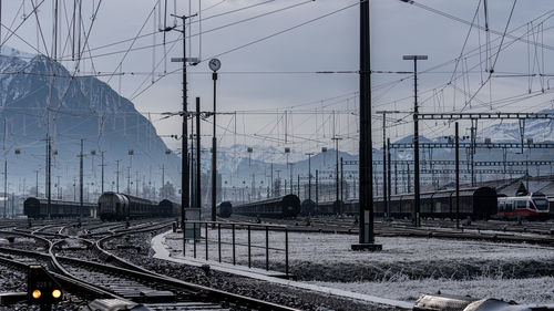 Trains on railroad track at shunting yard against sky