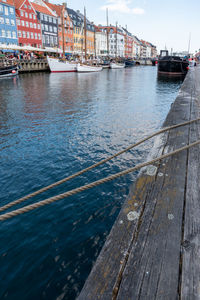 Sailboats moored in sea against sky in city