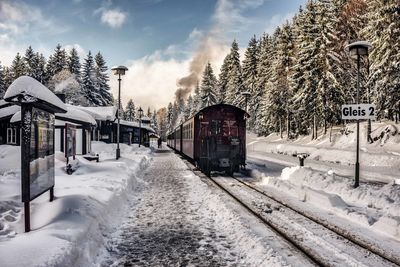 Train on railroad track against sky during winter