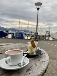 Coffee cup on table against sky