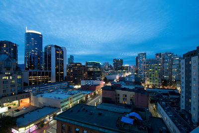 High angle view of illuminated buildings against blue sky