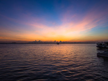 Scenic view of sea against dramatic sky during sunset