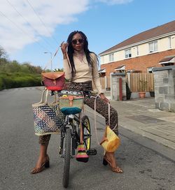 Woman riding bicycle on road in city