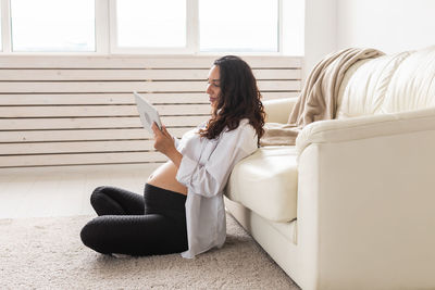 Woman sitting on sofa at home