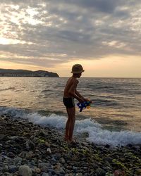 Full length of man standing on beach during sunset