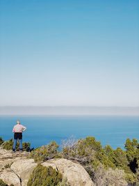 Rear view of man looking at sea against sky