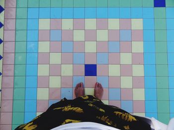 Low section of man on multi colored tiled floor