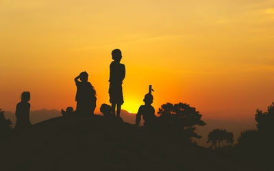 Silhouette people against sky during sunset