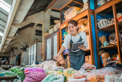 Portrait of young woman standing in market