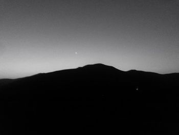 Silhouette mountains against clear sky at night