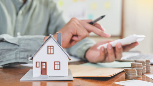 Close-up of woman hand holding paper outside house