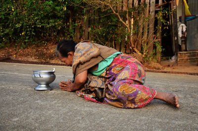 Side view of woman sitting outdoors