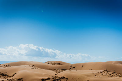 Scenic view of desert against clear blue sky