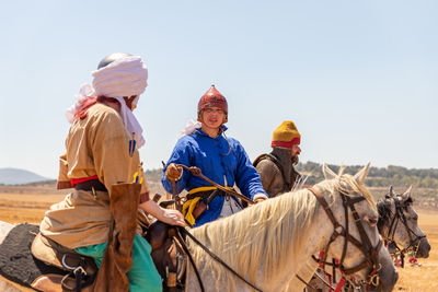 Panoramic view of people riding horses