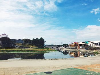 Scenic view of lake by buildings against sky