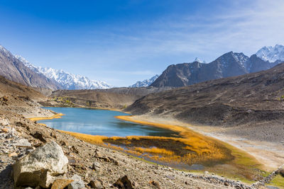 Scenic view of lake by mountains against sky