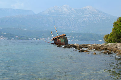 Abandoned boat in sea against sky