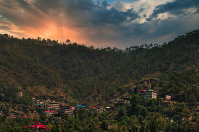 Scenic view of trees and mountains against sky during sunset