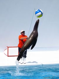 Man surfing on sea against clear sky