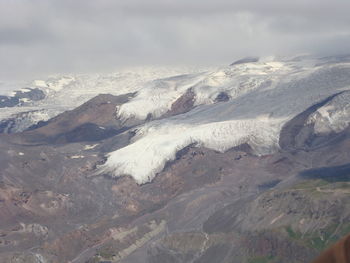 Aerial view of snowcapped mountains against sky