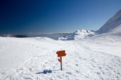 Snow on snowcapped mountain against clear blue sky