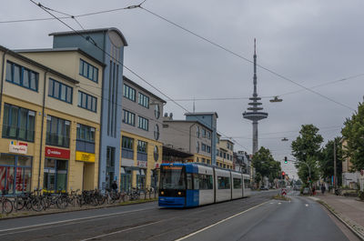 Cars on street in city against sky