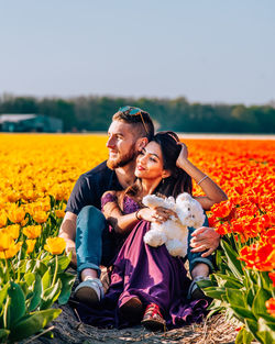 Happy young woman with flowers on field