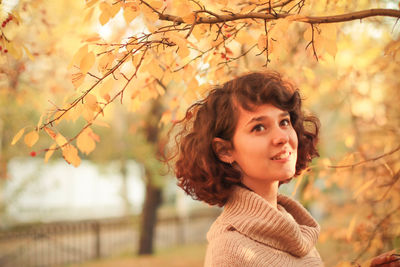 Portrait of smiling young woman during autumn