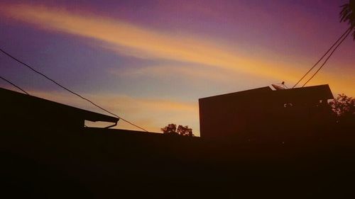 Low angle view of building against sky at sunset