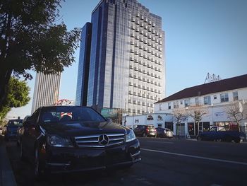 Cars on road in city against clear sky