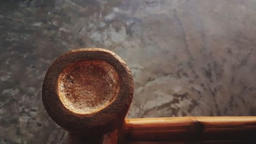 Close-up of rusty metal on wood against wall