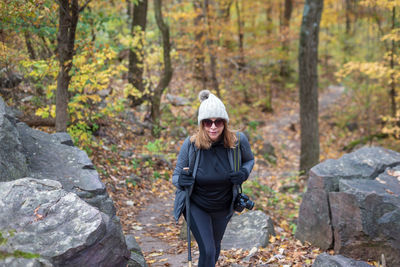 Full length of man standing on rock in forest