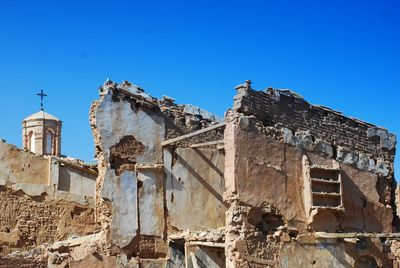 Low angle view of old building against clear blue sky