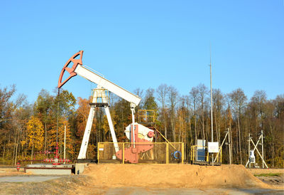 Traditional windmill on field against clear blue sky