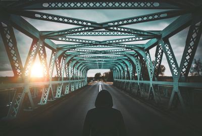 Rear view of woman standing on footbridge