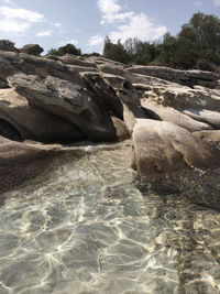 Rocks in sea against sky